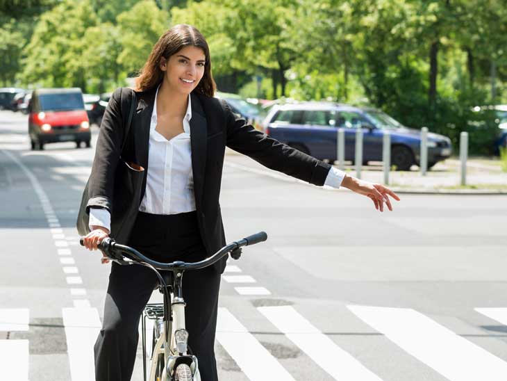 Woman on bike signalling turn.