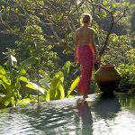 Woman walking by the pool belonging to one of the villas at the Damai, Bali