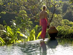 Woman walking by the pool belonging to one of the villas at the Damai, Bali