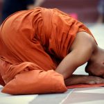 Buddhist monk saving prayers at the Schwedagon Pagoda in Yangon, Myanmar.