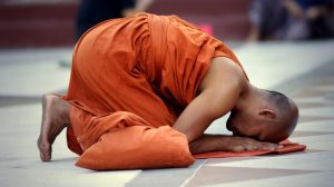 Buddhist monk saving prayers at the Schwedagon Pagoda in Yangon, Myanmar.