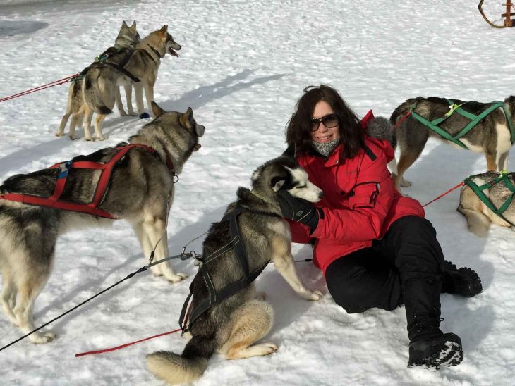 A happy Karin surrounded by the sled dogs.