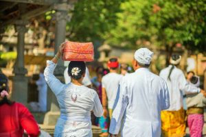 Couple going to temple with offerings in Bali, Indonesia.