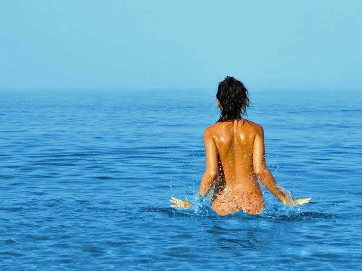 Nude woman in the sea.