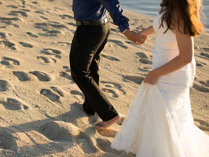 Bride and groom walking on the beach of Mauritius at sunset